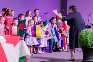 Children choir singing holding nation flags